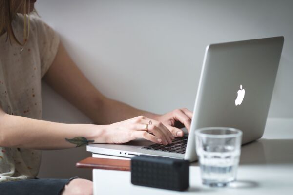 mujer escribiendo en un ordenador portatil